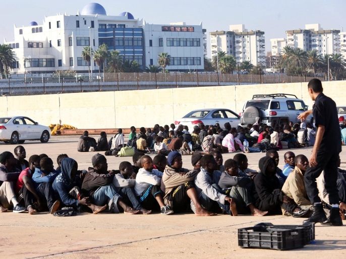 Some of the 220 refugees detained by the Libyan navy some 60 kilometers north of the capital, wait at the naval dock yard in Tripoli, Libya, 05 October 2015. According to reports Libyan naval forces have once again detained refugees attempting the dangerous Mediterranean crossing to Europe, as EU members continue to meet to formulate a solution to the some 500'000 refugees arriving so far in 2015 alone.