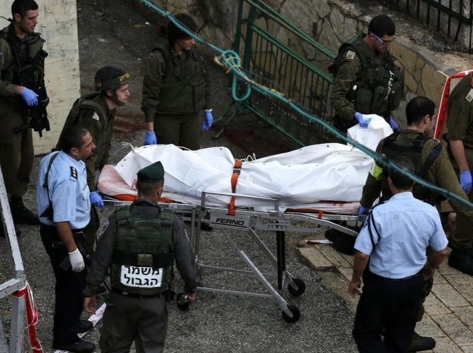 Employees of a private Israeli company transporting dead people, carry away the body of a 16 year old Palestinian girl in the West Bank city of Hebron, 25 October 2015. The girl reportedly was shot and killed after trying to stabb an Israeli policeman.