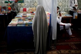An Afghan girl stands at a book kiosk during the inauguration of "Spring of Holy Quran" exhibition during the month of Ramadan, in Kabul, Afghanistan June 25, 2015. REUTERS/Ahmad Masood