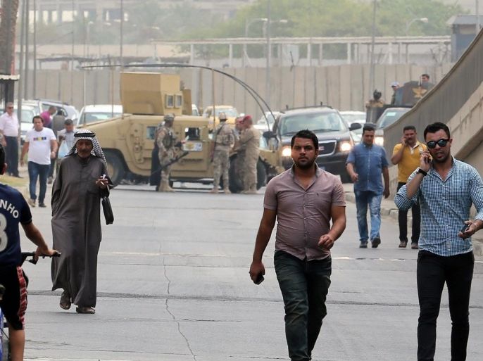 Iraqi security forces close the roads around the heavily guarded Green Zone as people walk to join a demonstration against the Iraqi Supreme Court's top judge, Midhat al-Mahmoud, in Baghdad, Iraq, Monday, Aug. 31, 2015. (AP Photo/Khalid Mohammed)