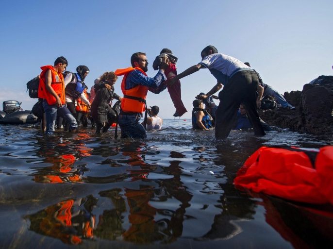 Migrants, who came across Turkey, make land from an overloaded rubber dinghy as they arrive at the coast near Mithimna, Lesbos island, Greece, 04 October 2015. Lesbos - the third-largest Greek island and home to nearly 90,000 people - has been overwhelmed with migrants from Syria, Afghanistan and Iraq trying to reach Europe. More than 200,000 refugees arrived on the island this year alone, according to the UN refugee agency. Many of the refugees begin their journey to Lesbos across sparkling Aegean waters in Turkey. EPA/ZOLTAN BALOGH HUNGARY OUT