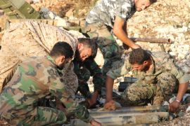In this photo taken on Saturday, Oct. 10, 2015, Syrian army personnel prepare artillery ammunition in Latakia province, about 12 miles from the border with Turkey, Syria. Backed by Russian airstrikes, the Syrian army has launched an offensive in central and northwestern regions. (Alexander Kots/Komsomolskaya Pravda via AP)