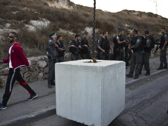 Israeli border policemen place a concrete barrier as they set up a checkpoint in Jabel Mukaber, in an area of the West Bank that Israel captured in a 1967 war and annexed to the city of Jerusalem October 14, 2015. Israel started setting up roadblocks in Palestinian neighbourhoods in East Jerusalem and deploying soldiers in cities across the country on Wednesday to try to combat the worst surge of violence in months. Seven Israelis and 31 Palestinians, including assailants, children and protesters in violent anti-Israeli demonstrations, have been killed in two weeks of bloodshed. REUTERS/Ronen Zvulun
