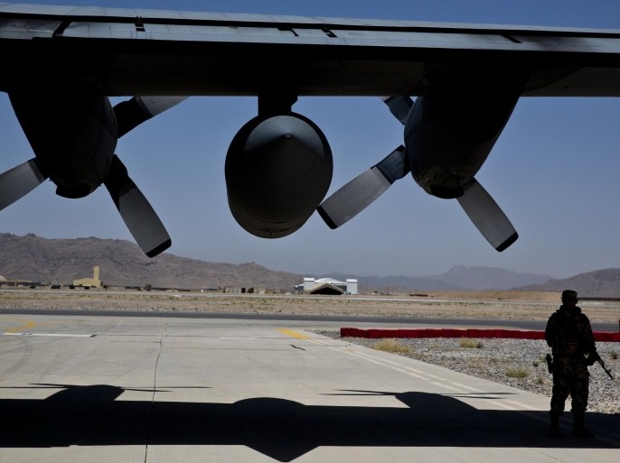 A NATO soldier stands guard under the wing of a C-130 Hercules aircraft, that belongs to the Afghan National Army, in Kandahar Air Field, Afghanistan, Tuesday, Aug. 18, 2015. Since the departure from Afghanistan last year of most international combat troops, Afghan security forces have been fighting the insurgency alone. Figures show that casualty rates are extremely high, reflecting an emboldened Taliban testing the commitment and strength of the Afghan military. (AP Photo/Massoud Hossaini)
