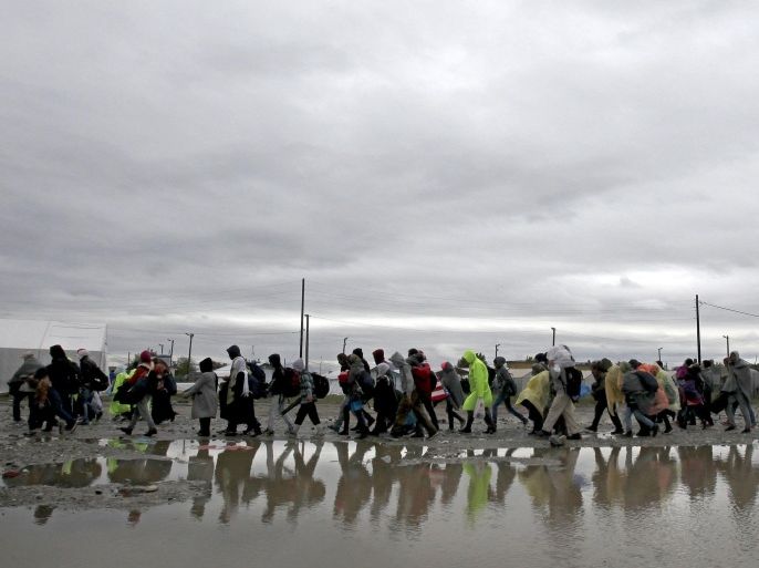 Migrants and refugees walk in the rain and cold towards the transit camp for refugees, just after crossing the border from Greece near the southern Macedonian town of Gevgelija, on Thursday, Oct. 22, 2015, as migrants make their way across Europe by the tens of thousands, fleeing war or seeking a better life. A U.N. refugee agency field officer says a large number of families with small children have been among the thousands of migrants and it is a tendency seen over the last couple of weeks. (AP Photo/Boris Grdanoski)
