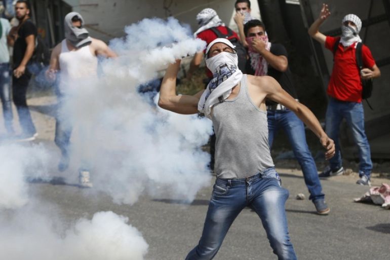 A masked Palestinian protester hurls back a tear gas canister fired by Israeli troops during clashes in the West Bank city of Hebron October 18, 2015. Forty-one Palestinians and seven Israelis have died in recent street violence, which was in part triggered by Palestinians' anger over what they see as increased Jewish encroachment on Jerusalem's al-Aqsa mosque compound. REUTERS/Mussa Qawasma