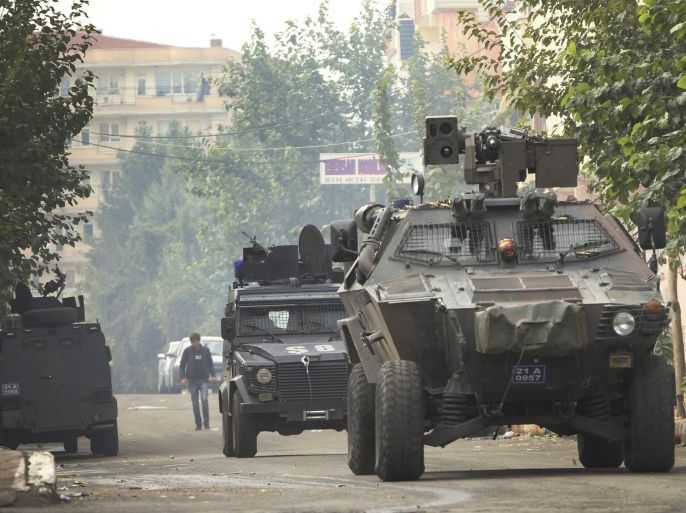 Armoured police vehicles patrol as they block a road leading to the site of armed clashes with militants in Diyarbakir, southeastern Turkey, Monday, Oct. 26, 2015. Police raided a house used by a suspected cell of the Islamic State group triggering a clash that killed up to seven militants and two policemen, Turkish media reports said. It was not immediately clear if the operation was linked to suicide bombings of a peace rally in the capital Ankara earlier this month that killed 102 people. (AP Photo/Mahmut Bozarslan)