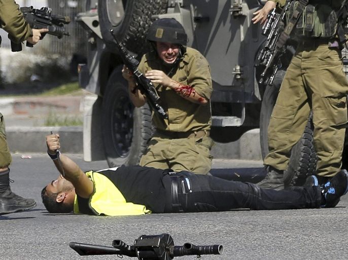 A Palestinian protester holding a knife lays on the ground after he stabbed an Israeli soldier and was shot and killed, in the West Bank city of Hebron, 16 October 2015. The attacker pretending to be a local news photographer was wearing a t-shirt marked with 'PRESS' as he advanced and stabbed the Israeli soldier, it was reported. Israel and the Palestinian territories experience a wave of violence and anger in addition to the tight security and after various stabbing attacks, especially in the city of Jerusalem. EPA/ABED AL HASLHAMOUN ATTENTION EDITORS: PICTURE CONTAINS GRAPHIC CONTENT