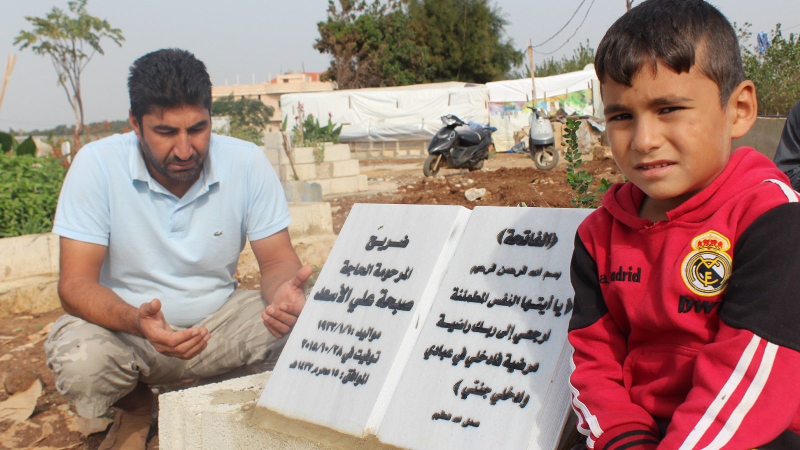 فوزي جابر مع ابنه فوق قبر والدته (الجزيرة نت)