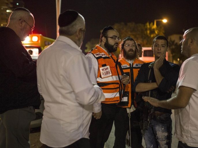 Israelis gather at the scene of an attack in Kiryat Gat, Israel, Saturday Nov. 21, 2015. An assailant stabbed and wounded four Israelis, including a 13-year-old girl, in Kiryat Gat, on Saturday before fleeing the scene, setting off a large manhunt, police said. (AP Photo/Tsafrir Abayov)