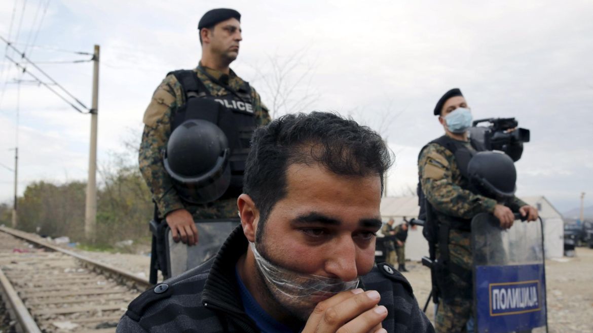 A stranded Iranian migrant has his lips shield as he sits on rail tucks at the borderline between Greece and Macedonia near the Greek village of Idomeni November 23, 2015. A dozen of other Iranian migrants are on hunger-strike for a second day following a denial of passage by Macedonian authorities. Balkan countries have begun filtering the flow of migrants to Europe, granting passage to those fleeing conflict in the Middle East and Afghanistan but turning back others from Africa and Asia, the United Nations and Reuters witnesses said. REUTERS/Yannis Behrakis