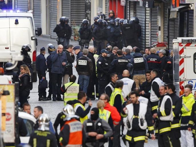 Police officers and rescue workers gather in a street of Saint-Denis, near Paris, Wednesday, Nov. 18, 2015. A woman wearing an explosive suicide vest blew herself up Wednesday as heavily armed police tried to storm a suburban Paris apartment where the suspected mastermind of last week's attacks was believed to be holed up, police said. (AP Photo/Peter Dejong)