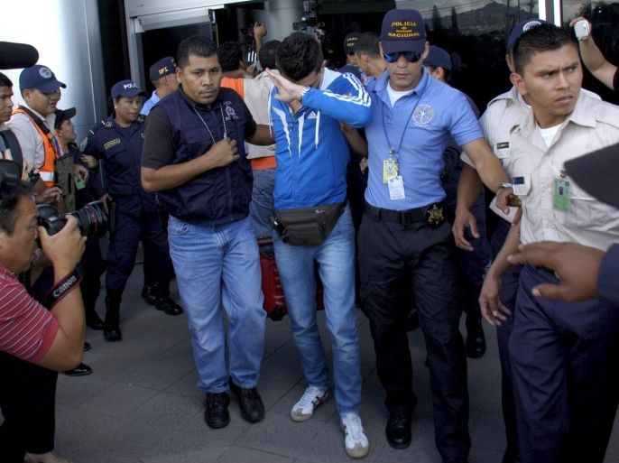 Policemen escort one of five Syrian men detained at Toncontin international airport in Tegucigalpa, Honduras, November 18, 2015. Honduran authorities have detained five Syrian nationals who were trying to reach the United States using stolen Greek passports, but there are no signs of any links to last week's attacks in Paris, police said. The Syrian men were held late on Tuesday in the Honduran capital, Tegucigalpa, on arrival from Costa Rica, and had been planning to head to the border with neighboring Guatemala. The passports had been doctored to replace the photographs with those of the Syrians, police said. REUTERS/Stringer EDITORIAL USE ONLY. NO RESALES. NO ARCHIVE.