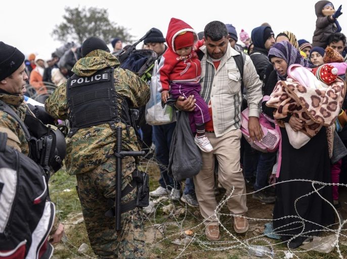 Refugees try to pass over a barbed wire fence as they wait to cross the Greek-Macedonian border after Macedonia has started granting passage only to refugees from Syria, Iraq and Afghanistan, near Gevegelija, The Former Yugoslav Republic of Macedonia, 20 November 2015. Macedonia, Serbia and Croatia have started restricting access to migrants on the Balkan route to Syrians, Iraqis and Afghans. It is a part of a joint effort to reduce the number of asylum seekers streaming into the European Union.