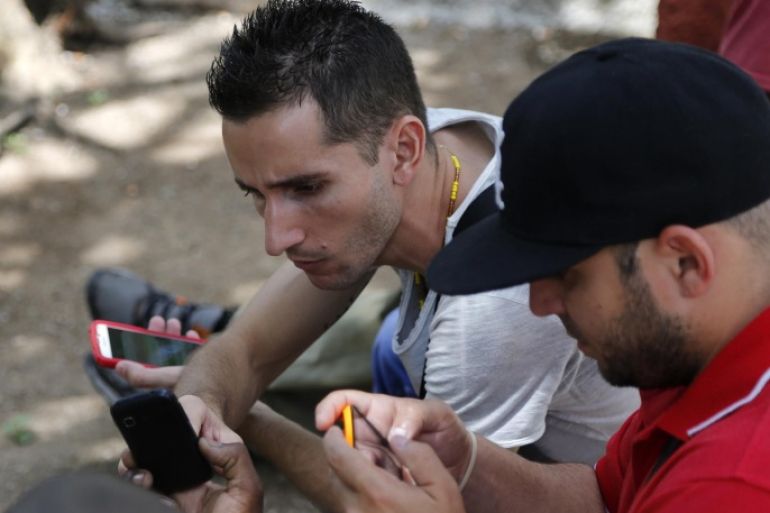 Internet users go online with their smartphones using the first public Wi-Fi hotspot in Havana, Cuba, Thursday, July 2, 2015. Cuban authorities have launched public Wi-Fi hotspots along a main avenue that is the heart of the capital´s cultural and social life. Its the first step in government promises to gradually roll out such connectivity options on an island that the internet revolution has largely passed by. (AP Photo/Desmond Boylan)