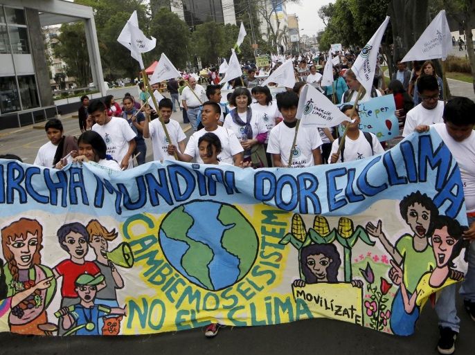 Students holding a banner take part in a rally ahead of the 2015 Paris Climate Change Conference (COP21), in Lima, Peru, November 29, 2015. REUTERS/Mariana Bazo