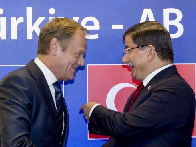 Turkish Prime Minister Ahmet Davutoglu (R) is welcomed by European Council President Donald Tusk at the start of an EU-Turkey summit, in which the EU seeks Turkish help to slow the influx of migrants into southeastern Europe, in Brussels, Belgium November 29, 2015. REUTERS/Thierry Monasse/Pool