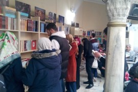 قراء يطالعون على الكتب برفوف معرض الكتاب العربي الأول