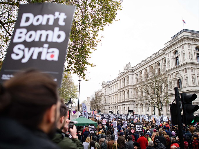 Demonstrators hold placards as they protest outside the entrance to Downing Street in central London on November 28, 2015, against the British government's proposed involvement in air strikes against the Islamic State (IS) group in Syria. Thousands of people were expected to protest in London Saturday against Britain potentially joining air strikes against the Islamic State (IS) group in Syria. Parliament is expected to vote on the issue next week after Prime Minister David Cameron pushed MPs to back the move in the wake of this month's Paris attacks. AFP PHOTO / LEON NEAL