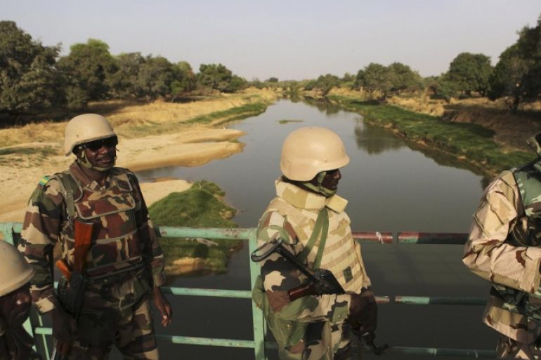 Nigerien soldiers patrol on a bridge above the Komadougou Yobe river which separates Niger from Nigeria in Diffa, Niger, March 25, 2015. REUTERS/Joe Penney