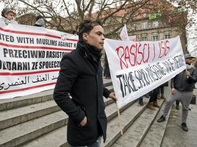People hold banners during a demonstration of members of Muslim community and groups fighting discrimination against Muslims after the Paris attacks, in Poznan, Poland November 29, 2015. Banner on right reads "Racism and ISIS - the same thinking, other methods" REUTERS/Lukasz Cynalewski/Agencja Gazeta ATTENTION EDITORS - THIS PICTURE WAS PROVIDED BY A THIRD PARTY. THIS PICTURE IS DISTRIBUTED EXACTLY AS RECEIVED BY REUTERS, AS A SERVICE TO CLIENTS. POLAND OUT. NO COMMERCIAL OR EDITORIAL SALES IN POLAND.