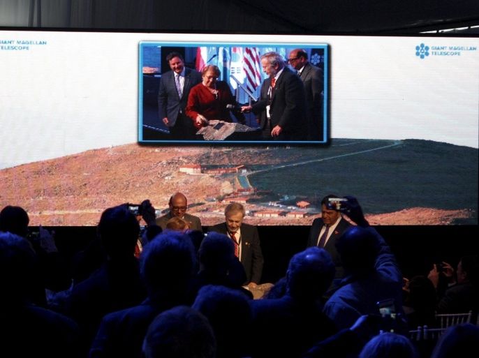 Chile's President Michelle Bachelet (C in the screen) attends the opening ceremony of the construction of The Giant Magellan Telescope (GMT) at Las Campanas hill near Vallenar town, Chile, November 11, 2015. Bachelet put hammer to stone on an Andean mountaintop on Wednesday eve to mark the start of construction for one of the world's most advanced telescopes, an instrument that may help shed light on the possibility of life on distant planets. Picture taken November 11, 2015. REUTERS/Gram Slattery EDITORIAL USE ONLY. NO RESALES. NO ARCHIVE