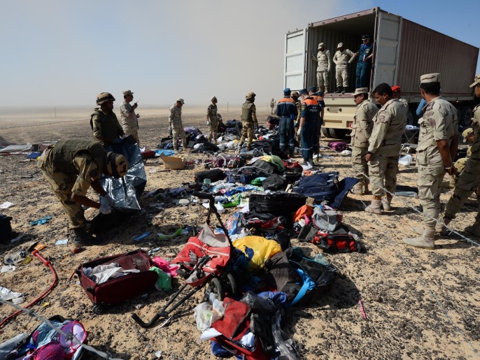 جنود مصريون يجمعون بقايا حقائب ركاب الطائرة المنكوبة بموقع سقوطها في وادي الظلمات بسيناء (أسوشيتد برس)