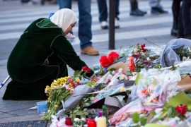 A woman lays flowers in front of the memorial set in front of the 'Petit Cambodge' restaurant in Paris, France, 15 November 2015. At least 129 people were killed in a series of terrorist attacks in Paris late 13 November.