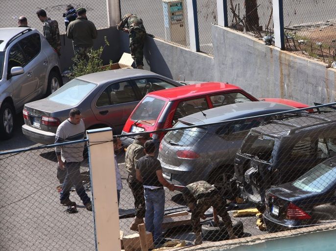 Lebanese army explosives experts dismantle a car bomb that was found in a public parking lot, in the Corniche al-Mazraa neighborhood of Beirut, Lebanon, Wednesday, Feb. 12, 2014. Lebanese security forces have sealed off a section of a predominantly Sunni neighborhood in west Beirut after an explosives-laden car was reported parked in the area. The troops dismantled the vehicle that contained 100 kilograms of explosives, Lebanon's state news agency said. (AP Photo/Hussein Malla)