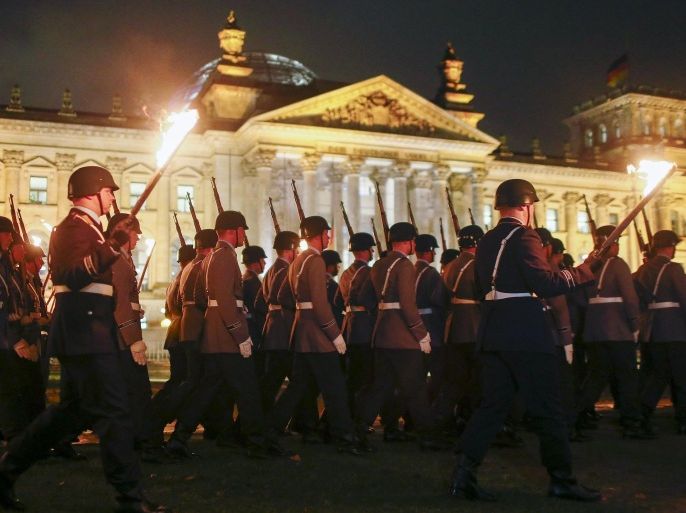 Soldiers march with torches during a Great Tattoo of the German Armed Forces Bundeswehr in front of the Reichstag building in Berlin, Germany, November 11, 2015. Bundeswehr celebrates its 60th anniversary. REUTERS/Hannibal Hanschke