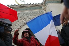 A French Muslim, of Algeria origin, who wants to be named "Cherif" talks to the media, holding a French flag, in front of the Great Mosque of Paris after the Friday priest, in Paris, France, Friday, Nov. 20, 2015 one week after the Paris attacks. France called Friday on its European Union partners to take immediate and decisive action to toughen the bloc's borders and prevent the entry of more violent extremists. (AP Photo/Francois Mori)