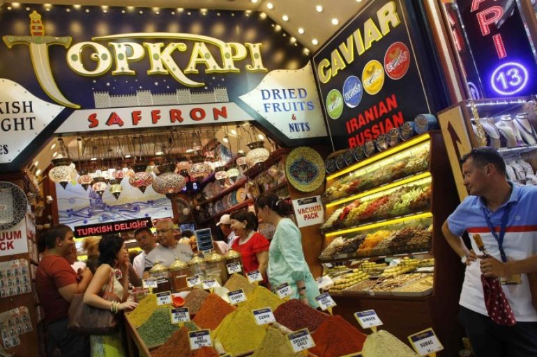 Tourists from Kazakhstan and Russia shop at a store at the Spice market, also known as the Egyptian Bazaar, in Istanbul August 23, 2013. The number of foreign visitors arriving in Turkey grew at its slowest pace for eight months in July, as the impact of anti-government protests and the Muslim fasting month of Ramadan took their toll, data showed on Friday. Foreign arrivals rose 0.48 percent year-on-year last month to 4.59 million people, according to the Tourism Ministry figures, the lowest rise since November. The number of visitors rose 4.93 percent the previous month. REUTERS/Murad Sezer (TURKEY - Tags: POLITICS TRAVEL)