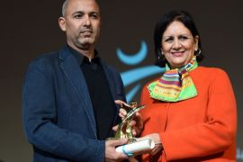 Moroccan director Mohamed Mouftakir (L) receives from Tunisian Culture Minister Latifa Lakhdar the Golden Tanit award for his film "L'orchestre des aveugles" during the closing ceremony of the 26th Carthage Film Festival on November 28, 2015 in the Tunisian capital Tunis. AFP PHOTO / FETHI BELAID