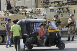 Egyptians drive their traditional tok-tok in front of armored vehicles guarding Torah Prison, where ousted President Hosni Mubarak is held in Cairo, Egypt, Wednesday, Aug. 21, 2013. An Egyptian court ordered Wednesday the release of ousted President Hosni Mubarak, but it is not yet clear if the ailing ex-leader will walk free after over two years in detention, officials said. The prospects of Mubarak’s release after the 2011 uprising against him, and a slew of court cases that made him the first Arab leader to be tried by his own people, are likely to further fuel the rest that has hit Egypt following the military coup against his successor, the first freely elected president Islamist Mohammed Morsi. (AP Photo/Amr Nabil)