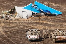FILE - In this file photo made available Monday, Nov. 2, 2015, and provided by Russian Emergency Situations Ministry, Egyptian Military on cars approach a plane's tail at the wreckage of a passenger jet bound for St. Petersburg in Russia that crashed in Hassana, Egypt, on Sunday, Nov. 1, 2015. After the Islamic State group claimed the downing of the Russian plane in Egypt and deadly suicide bombings in Lebanon and Turkey, the Paris attacks appear to signal a fundamental shift in strategy toward a more global approach that experts suggest is likely to intensify. (Maxim Grigoriev/Russian Ministry for Emergency Situations via AP, FILE)