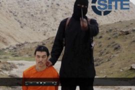 A masked, black-clad militant, who has been identified by the Washington Post newspaper as a Briton named Mohammed Emwazi, stands next to a man purported to be Kenji Goto in this still image from a video obtained from SITE Intel Group website February 26, 2015. The "Jihadi John" killer who has featured in several Islamic State beheading videos is Emwazi, a Briton from a middle class family who grew up in London and graduated from college with a degree in computer programming, the Washington Post newspaper said. In videos released by Islamic State (IS), the masked, black-clad militant brandishing a knife and speaking with an English accent appears to have carried out the beheadings of hostages including Americans and Britons. The Washington Post said Emwazi, who used the videos to threaten the West and taunt leaders such as President Barack Obama and British Prime Minister David Cameron, was believed to have travelled to Syria around 2012 and to have later joined IS. British government sources and the police refused to confirm or deny the report, citing a live anti-terrorism investigation, a position mirrored by a spokeswoman for Cameron. REUTERS/SITE Intel Group via Reuters TV (CIVIL UNREST CONFLICT POLITICS SOCIETY)ATTENTION EDITORS - THIS PICTURE WAS PROVIDED BY A THIRD PARTY. REUTERS IS UNABLE TO INDEPENDENTLY VERIFY THE AUTHENTICITY, CONTENT, LOCATION OR DATE OF THIS IMAGE. FOR EDITORIAL USE ONLY. NOT FOR SALE FOR MARKETING OR ADVERTISING CAMPAIGNS. THIS PICTURE IS DISTRIBUTED EXACTLY AS RECEIVED BY REUTERS, AS A SERVICE TO CLIENTS. MANDATORY CREDIT
