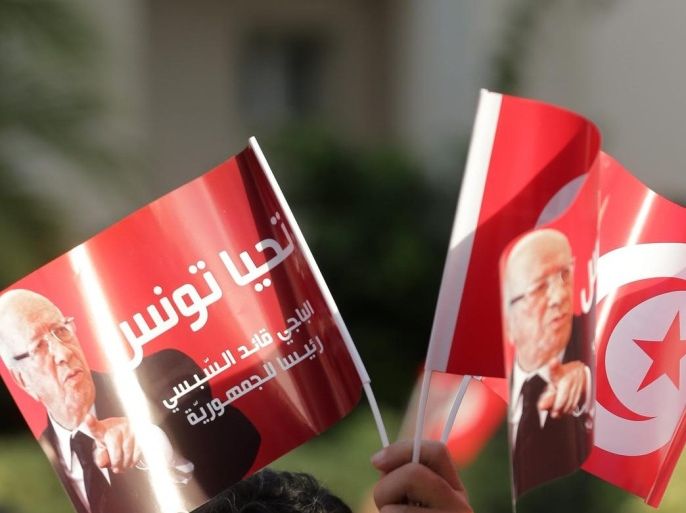 A Supporter of the Nidaa Tounes party holds pictures of Tunisian President Beji Caid Essebsi , in front of Nidaa Tounes party headquarters in Tunis, Tunisia, 03 November 2015. Tensions between two wings of Nidaa Tounes,that of Marzouk, former campaign manager of the president Beji Caid Essebsi and his son, Hafedh Caid Essebsi, 53 . Thirty-two of Nidaa Tounes' 86 lawmakers have already threatened to break away in protest at what they see as attempts by President Beji Caid Essebsi, to impose his son Hafhed as its leader. The president's office rejects those accusations.