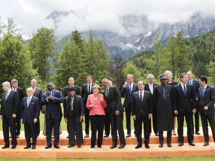 German Chancellor Angela Merkel, center left, speaks with U.S. President Barack Obama, center right, during a group photo of G-7 leaders and Outreach guests at the G-7 summit at Schloss Elmau hotel near Garmisch-Partenkirchen, southern Germany, Monday, June 8, 2015. Other leaders are front row left to right, Ethiopian President Hailemariam Desalegn, Canadian Prime Minister Stephen Harper, Tunisia's President Beji Caid Essebsi, Senegal President Macky Sall, Liberian President Ellen Johnson Sirleaf, French President Francois Hollande, Nigerian President Muhammadu Buhari, British Prime Minister David Cameron, Japanese Prime Minister Shinzo Abe. (AP Photo/Markus Schreiber)