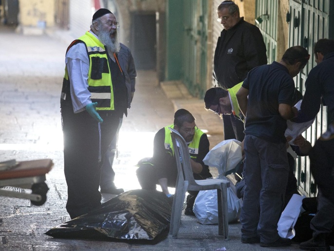 مسؤولون إسرائيليون يتفحصون جثة فلسطيني قتلته الشرطة في القدس بعد طعنه إسرائيليا (الأوروبية)