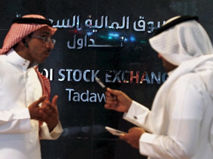 Traders talk as they monitor screens displaying stock information at the Saudi Stock Exchange (Tadawul) in Riyadh June 15, 2015. The chief executive of Saudi Arabia's stock exchange said on Monday he expected a flurry of licenses allowing the first foreign investors to buy shares there in coming weeks. To match Interview SAUDI-STOCKEXCHANGE/ REUTERS/Faisal Al Nasser