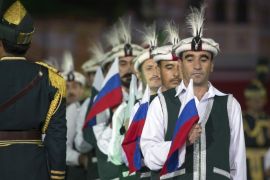 Members of the Armed Forces Band of Pakistan hold Russian and Pakistan national flags during the "Spasskaya Tower" International Military Orchestra Music Festival at the Red Square in Moscow, Russia, Friday, Sept. 4, 2015. (AP Photo/Pavel Golovkin)