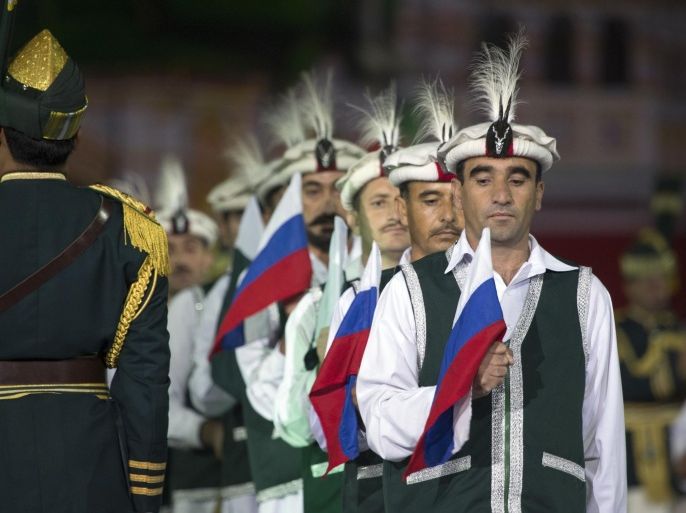 Members of the Armed Forces Band of Pakistan hold Russian and Pakistan national flags during the "Spasskaya Tower" International Military Orchestra Music Festival at the Red Square in Moscow, Russia, Friday, Sept. 4, 2015. (AP Photo/Pavel Golovkin)