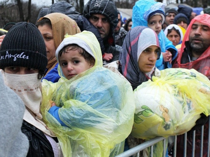 Refugees queue in the heavy rain, while waiting to be registered in a registration camp near Presevo, southern Serbia, 27 November 2015. Macedonia, Serbia and Croatia on 19 November 2015 have started restricting access to migrants on the Balkan route to Syrians, Iraqis and Afghans. It is a part of a joint effort to reduce the number of asylum seekers streaming into the European Union.