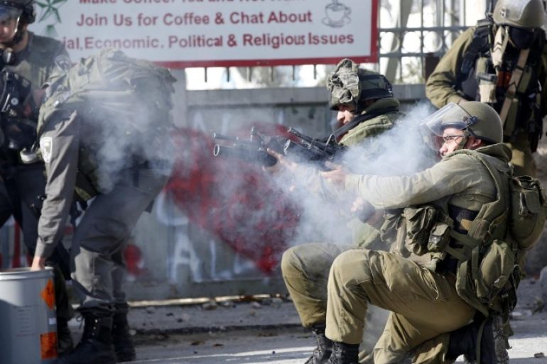 Israeli soldiers take up position during clashes with Palestinian protesters on the outskirts of the West Bank city of Bethlehem, 18 December 2015.