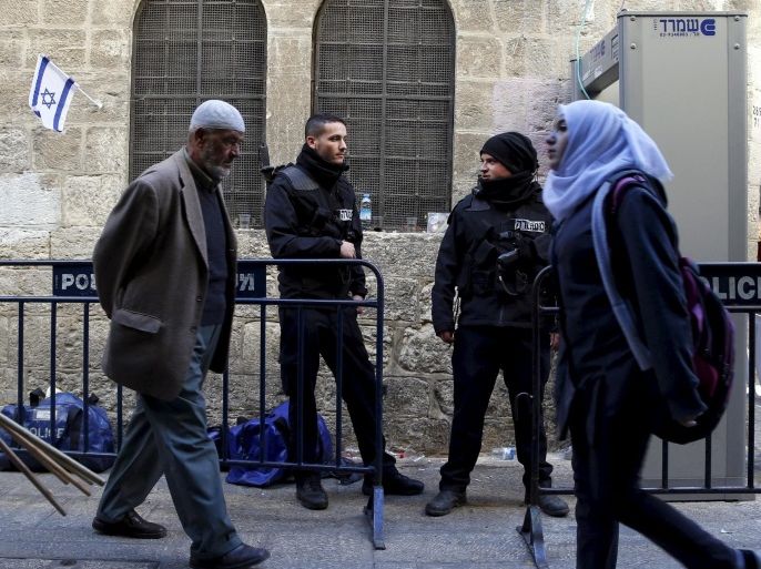 Palestinians walk past Israeli police officers in Jerusalem's Old City December 9, 2015. To match ISRAEL-PALESTINIANS/CASUALTIES REUTERS/Ammar Awad