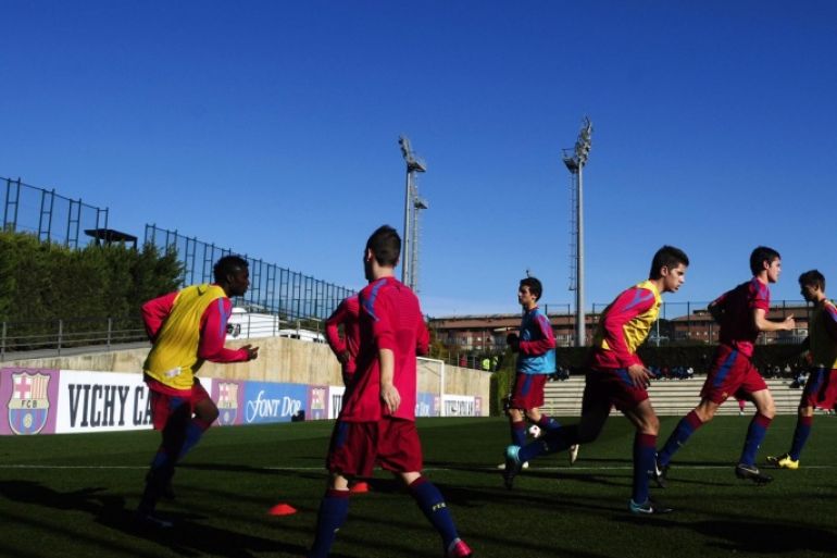 FILE - In this Jan. 8, 2011 file photo, Barcelona youth players from 'La Masia' football academy warm up at the Barcelona FC's Joan Gamper training camp in San Joan Despi, Spain. The Court of Arbitration for Sport on Tuesday Dec. 30, 2014 dismissed Barcelona's appeal and upheld the transfer ban FIFA imposed on the club for infringing regulations on registering minors as youth players. CAS said in a statement that “Barcelona had breached the rules regarding the protection of minors and the registration of minors attending football academies.” The ruling means Barcelona will be barred from signing any players in 2015. Barcelona is renowned for training and educating young players such as Lionel Messi and Andres Iniesta at it's La Masia academy, in the hope they develop the talent to graduate to the senior team. (AP Photo/Manu Fernandez, File)