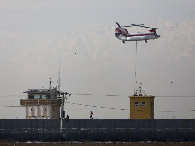 A Chinook helicopter flies over the Bagram Air Base north of Kabul February 13, 2014. REUTERS/Mohammad Ismail