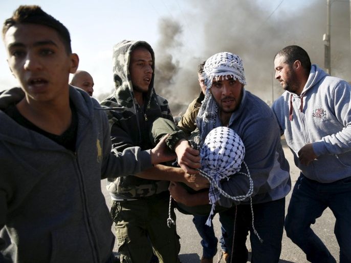 A wounded Palestinian protester is evacuated by comrades during clashes with Israeli troops in the West Bank village of Silwad, near Ramallah, December 11, 2015. REUTERS/Ammar Awad