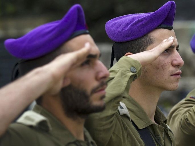 Israeli soldiers from the Givati brigade salute as a two-minute siren marking Holocaust Remembrance Day is sounded at Kibbutz Yad Mordechai, near the border with Gaza April 16, 2015. Israel on Thursday marks its annual memorial day commemorating the six million Jews killed by the Nazis during World War Two. REUTERS/Amir Cohen