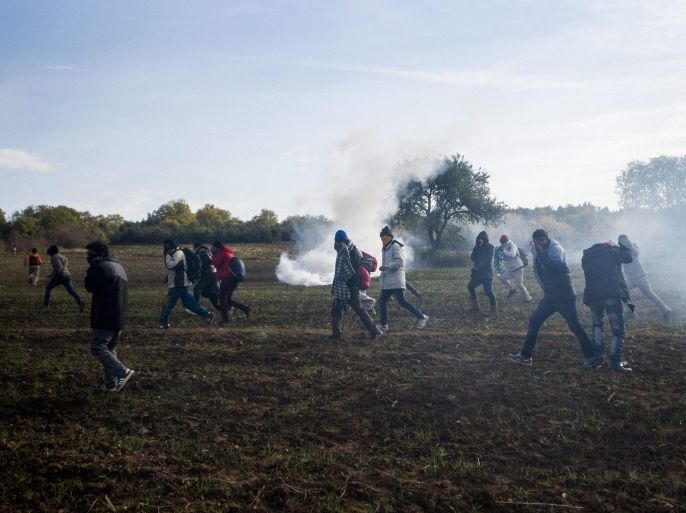A picture made available on 03 December 2015 shows migrants prevented from entering Macedonia fleeing pepper spray and smoke granades shot at them by Macedonian police on the Greek side of the border between Greece and Macedonia, near the Greek village of Idomeni, 02 December 2015. Macedonian authorities allow only migrants from war-torn countries and heading for rich EU states to cross the country while citizens of other states regarded as economic migrants are blocked by a fence built by Macedonia along this section of the border. EPA/ZOLTAN BALOGH HUNGARY OUT